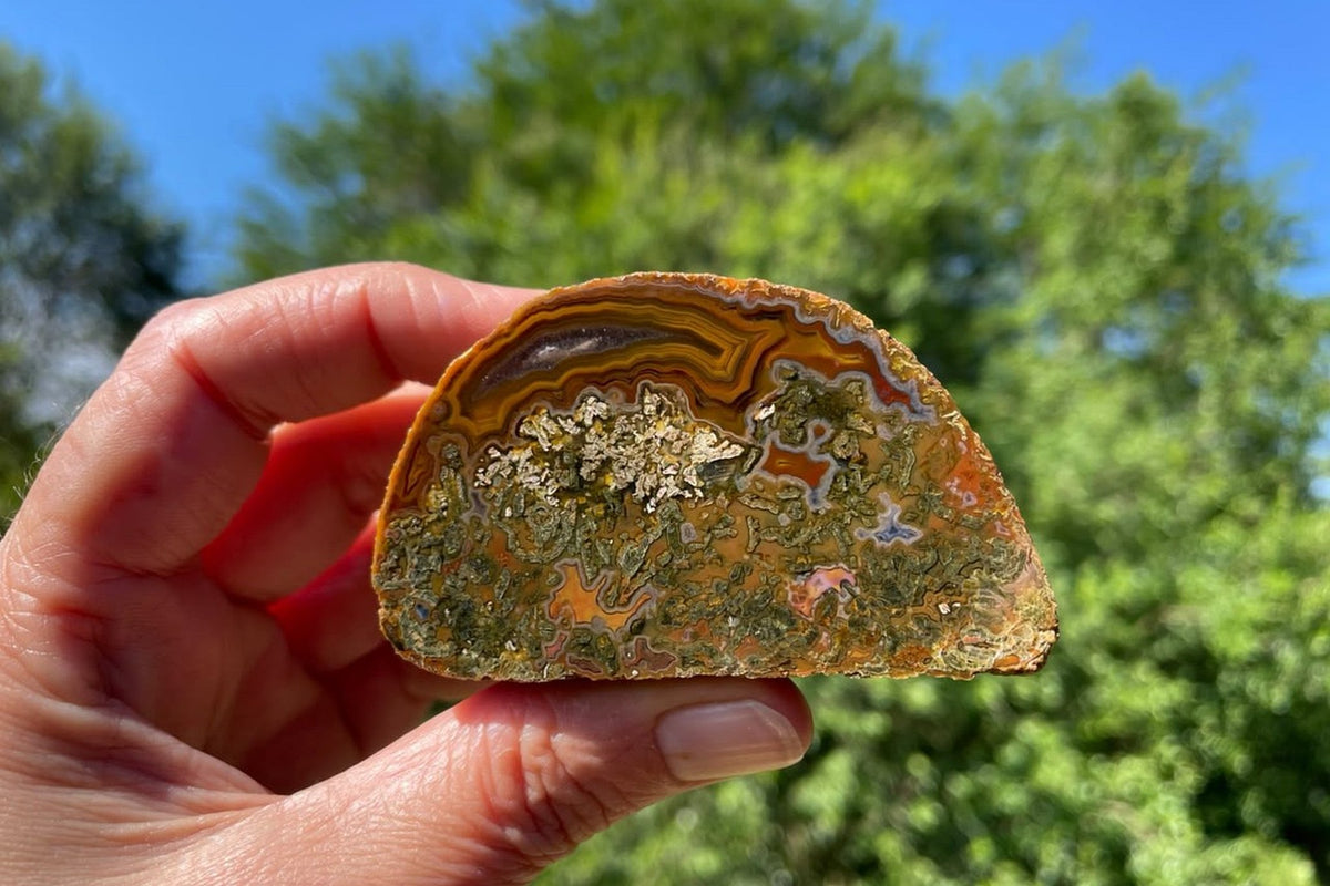 Lilangabi agate 72 mm, in-hand view for scale, collector specimen from the Lebombo Mountains.
