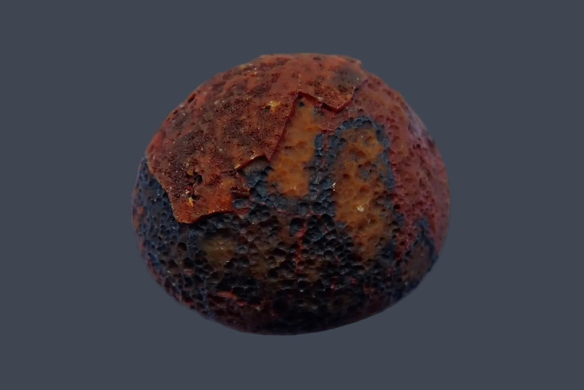 Lilangabi agate 49 mm, back view showing rough reddish-brown natural rind with dark patches, Lebombo Mountains.