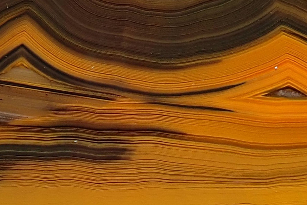 Lilangabi agate 82 mm – tightly packed gold and dark brown bands forming nested angular peaks above fine waterlines, with chromatography across the face.