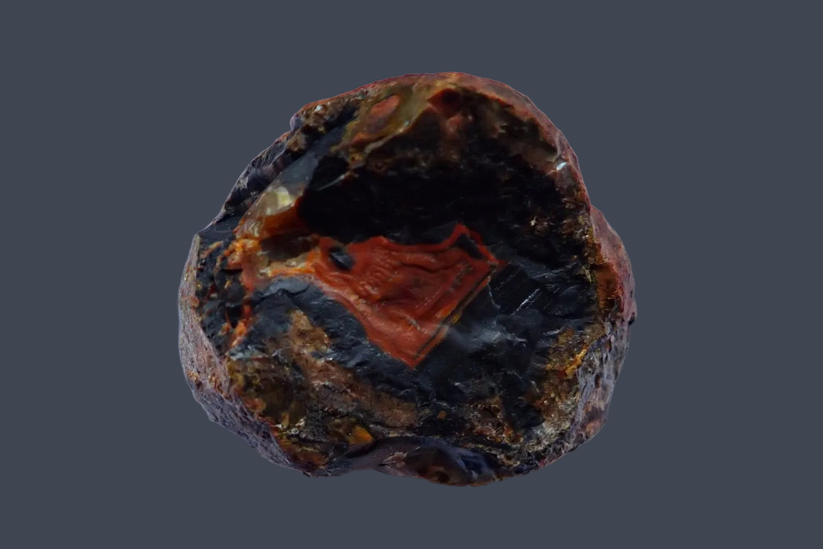 Lilangabi agate 63 mm – back view showing the rough natural surface in dark charcoal, brown and reddish orange, Lebombo Mountains.