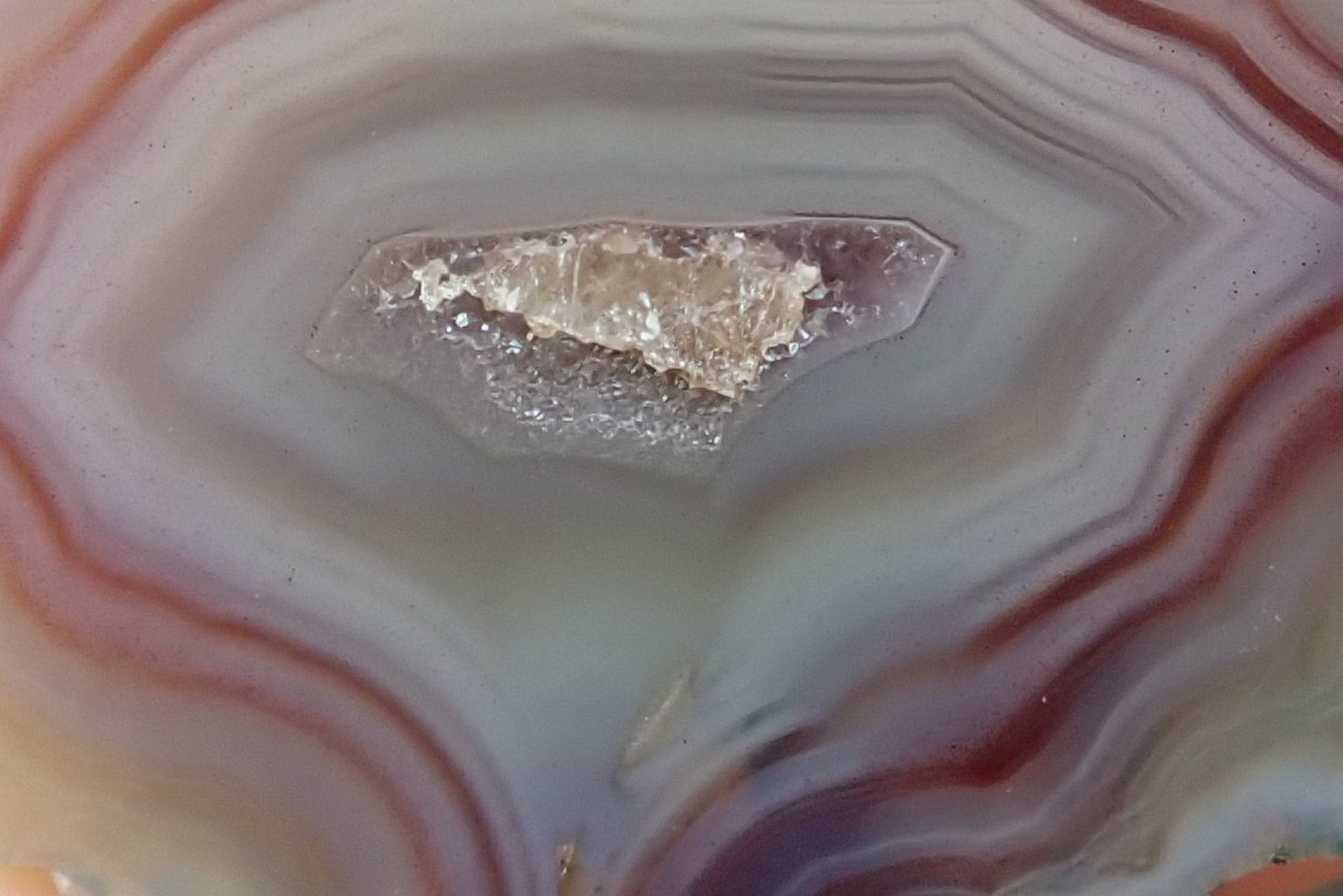Malawi agate 47 mm – face detail, angular fortification bands, central drusy vug with calcite crystal, flow channel
