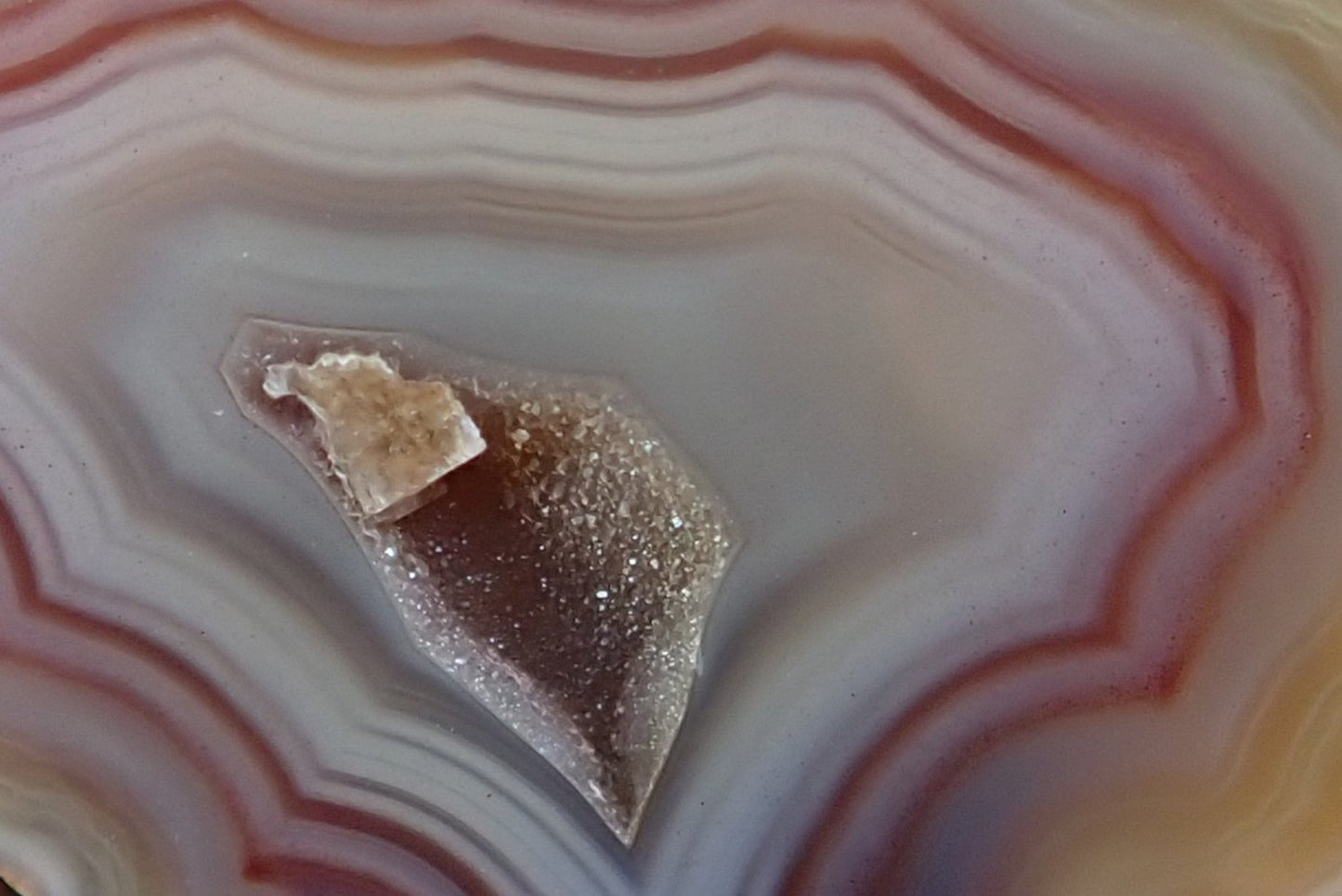 Malawi agate 47 mm – face detail, angular fortification bands, drusy vug with calcite crystal point, cream to mauve-purple