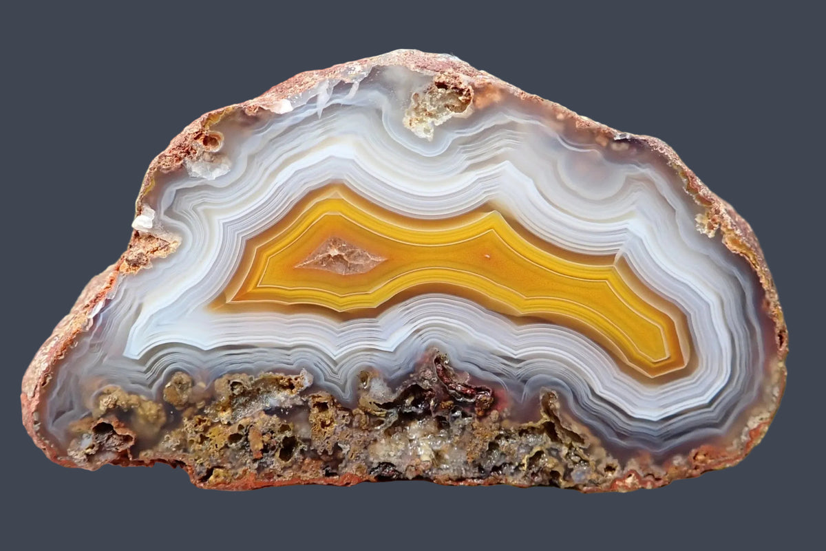 Malawi agate 57 mm, hand-polished face with a golden yellow centre, angular fortification banding and fine white-grey ghost bands, with scalloped lower banding, Ngabu, Malawi.
