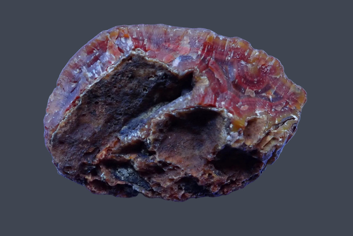 Malawi agate 74 mm – unpolished back with dark natural cavities and reddish-brown outer stone, from Ngabu, Malawi.