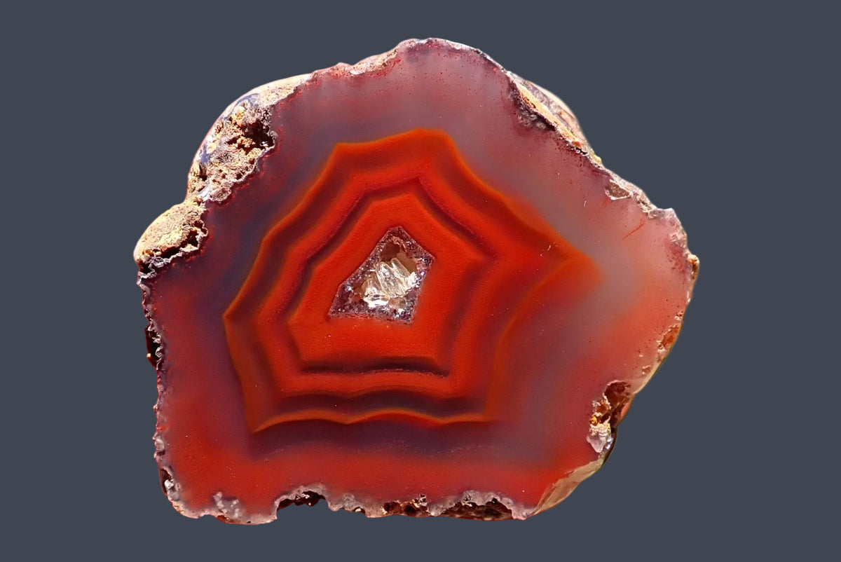 Malawi agate 41 mm – polished face with red-orange fortification and shadow banding around a crystalline centre, mauve-grey outer agate from Ngabu.
