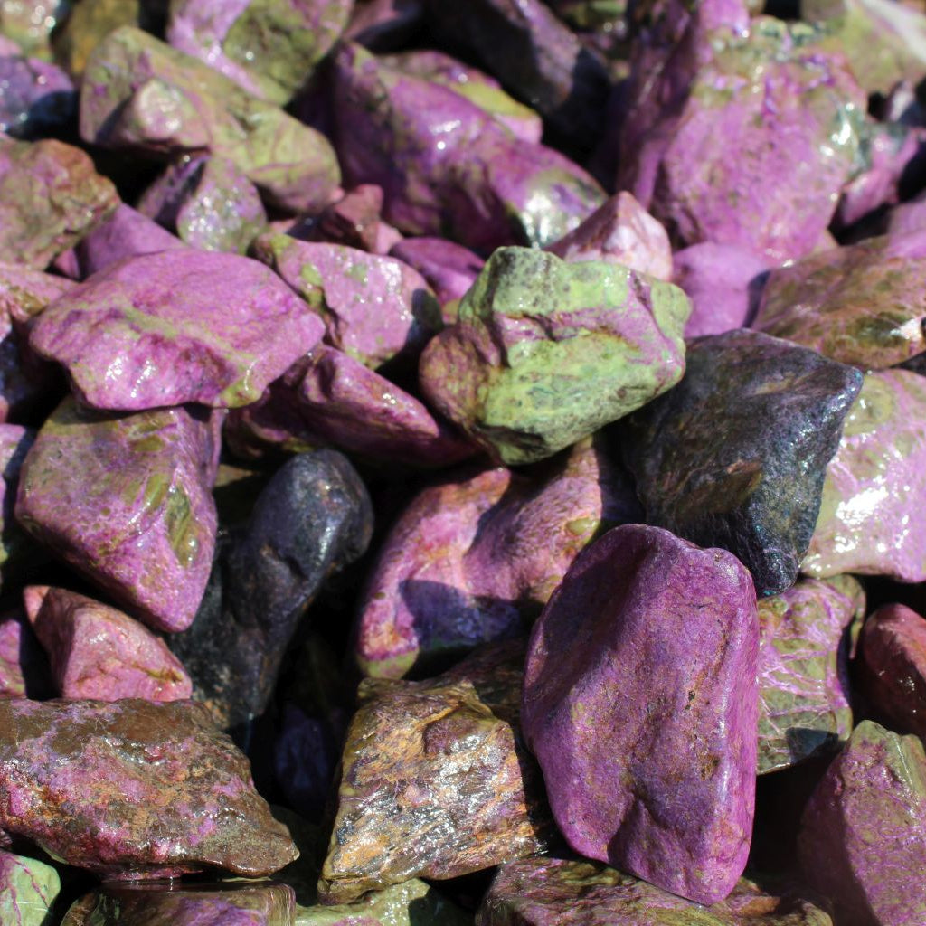 Wet natural stichtite rough specimens in serpentine matrix, Kaapsehoop, South Africa — bulk lot showing pink to purple colour range, wet finish | SKU STICHRsml