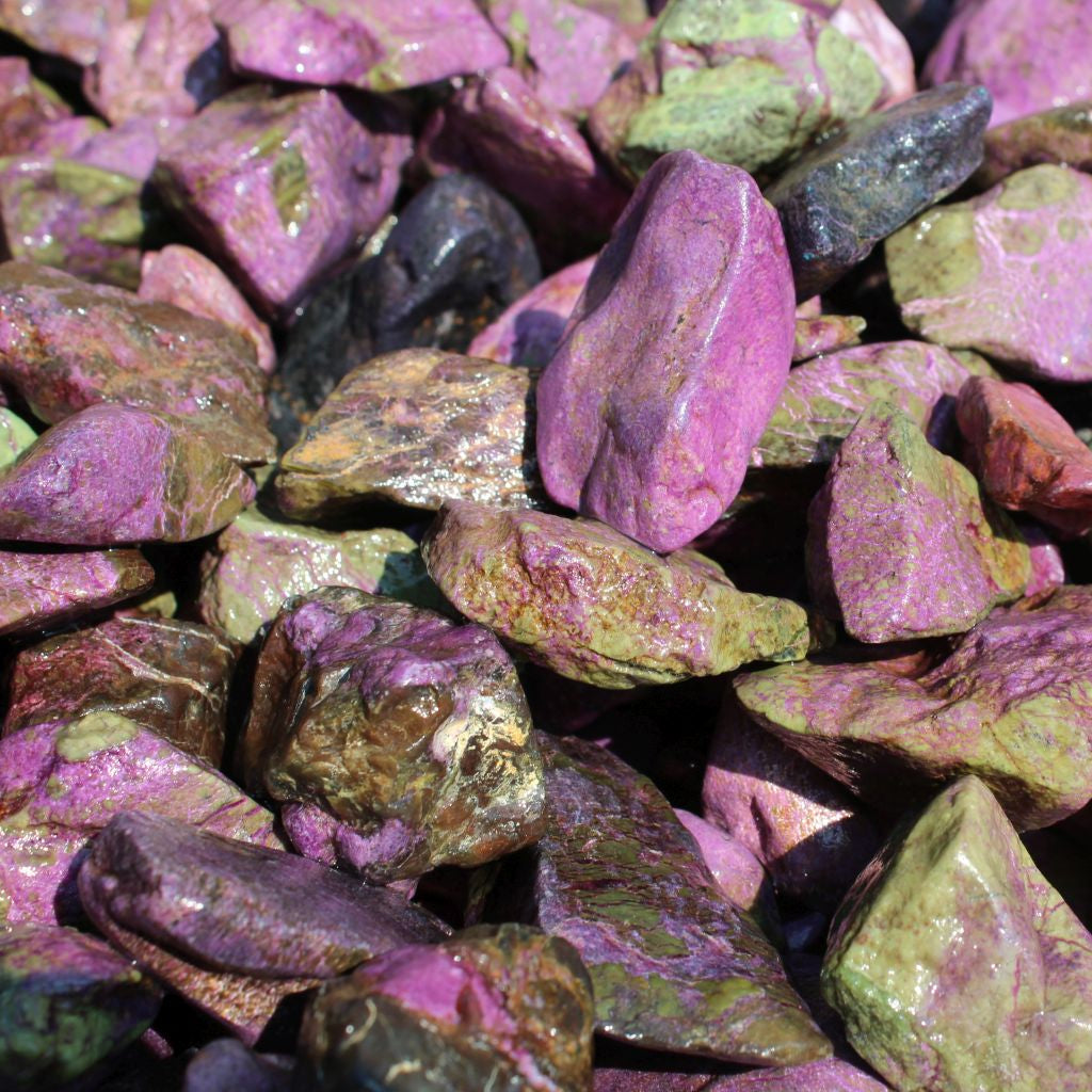 Wet natural stichtite rough specimens in serpentine matrix, Kaapsehoop, South Africa — bulk lot showing pink to purple colour range, wet finish | SKU STICHRsml