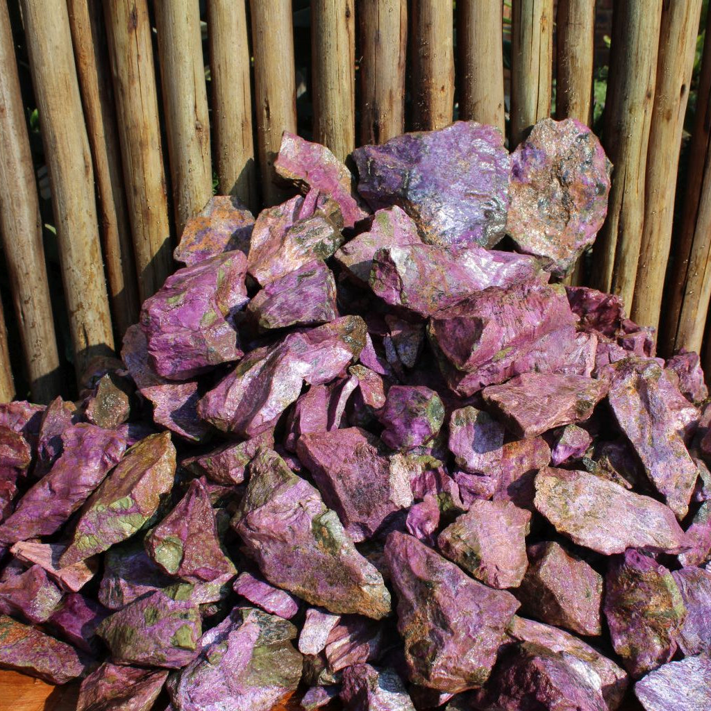 Wet natural stichtite specimen grade large rough in serpentine matrix, Kaapsehoop, South Africa — bulk lot showing pink-purple to green serpentine colour range, wet finish | SKU STICHSPEC
