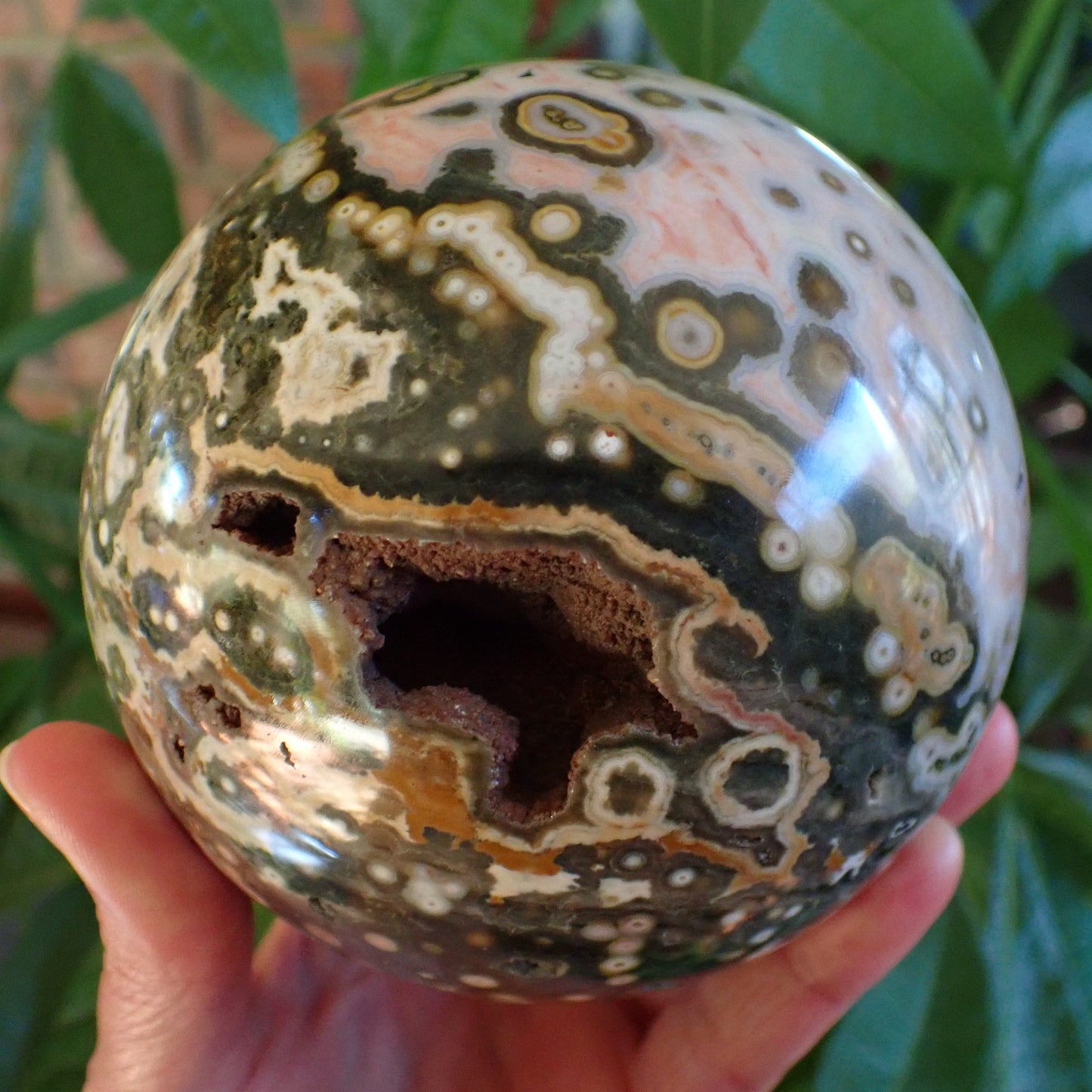 Ocean Jasper (Orbicular) Polished Sphere 115mm – vug from above, open cavity detail with amber and green surround, 8th Vein Marovato Madagascar | SKU OM00004
