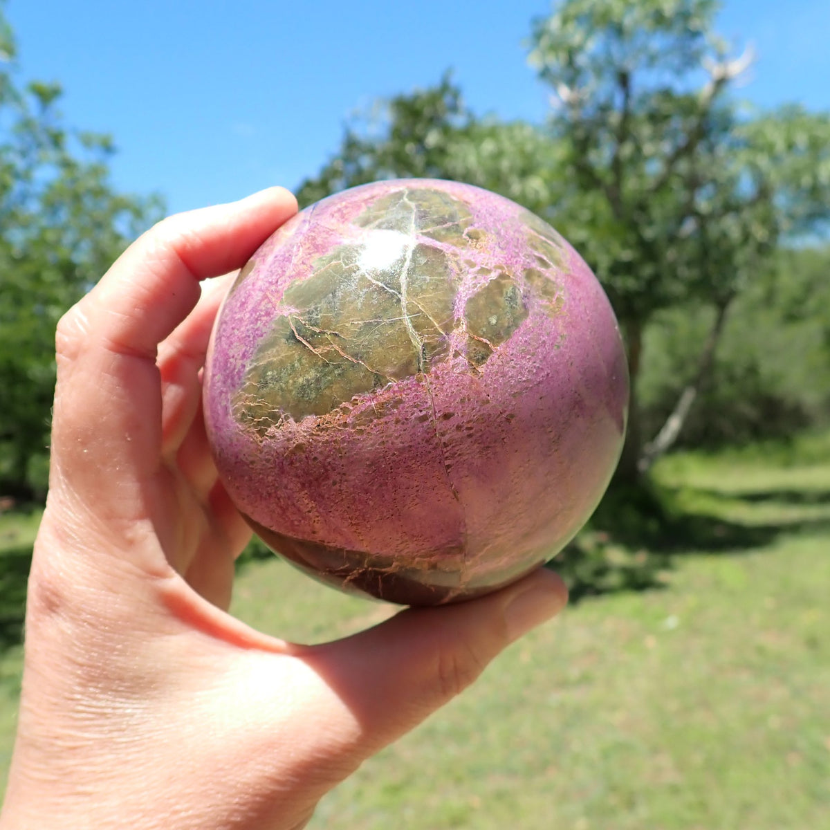 Stichtite with Serpentine sphere showing olive-green patches crossed by fine pale veins against pink-purple intergrowths.