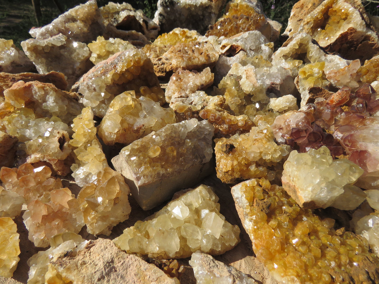 Wholesale limonite quartz Zambia – bulk lot showing formation variety, golden-yellow and white druzy plates, red phantom inclusion visible, variable limonite intensity | SKU LIMkg
