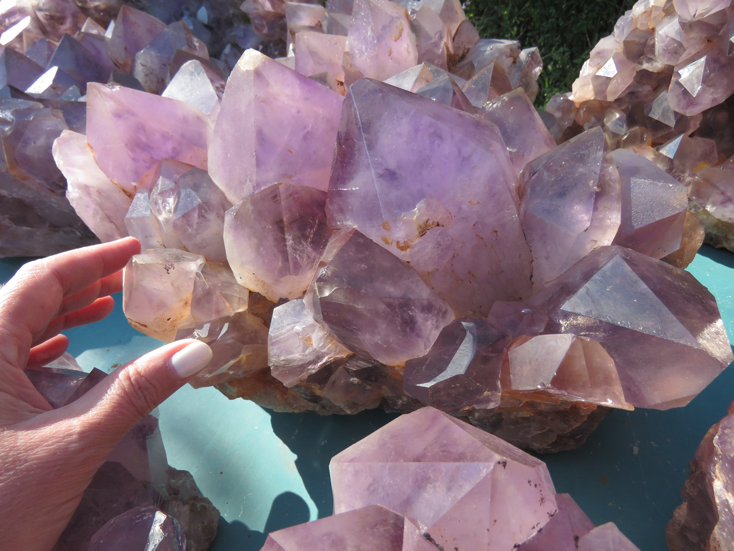 Wholesale Mumbwa amethyst Zambia – in-hand cluster showing dense multi-directional point growth, mid violet coloration, natural iron spotting on crystal faces | SKU MUMkg