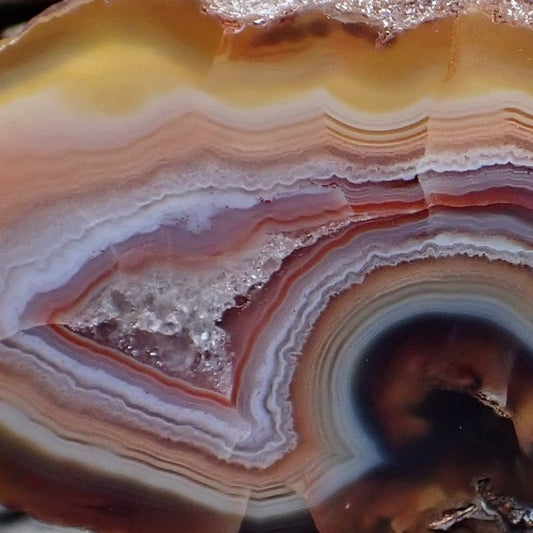 close-up of a malawi agate with crazy lace banding around a crystalline chamber