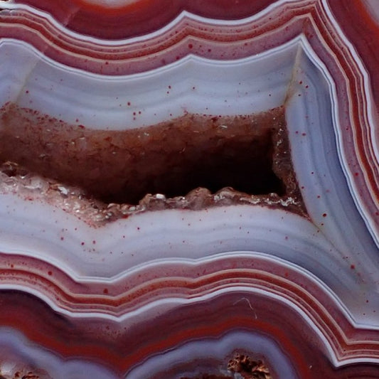 close-up of a Malawi candy agate with bold red and almost purple patterning around a drusy centre