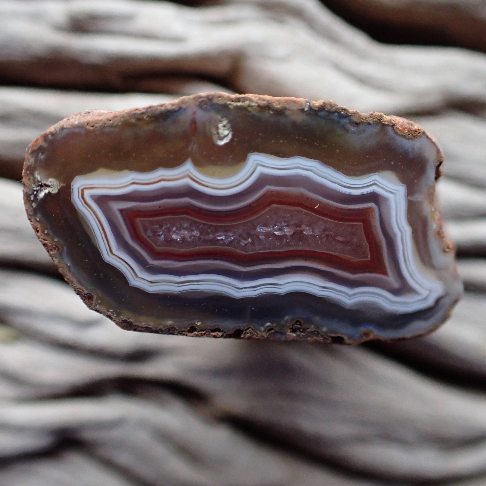 Polished Malawi agate from the Ngabu region with nice clean solid looking banding in white, purple/grey and red around a neat crystalline centre