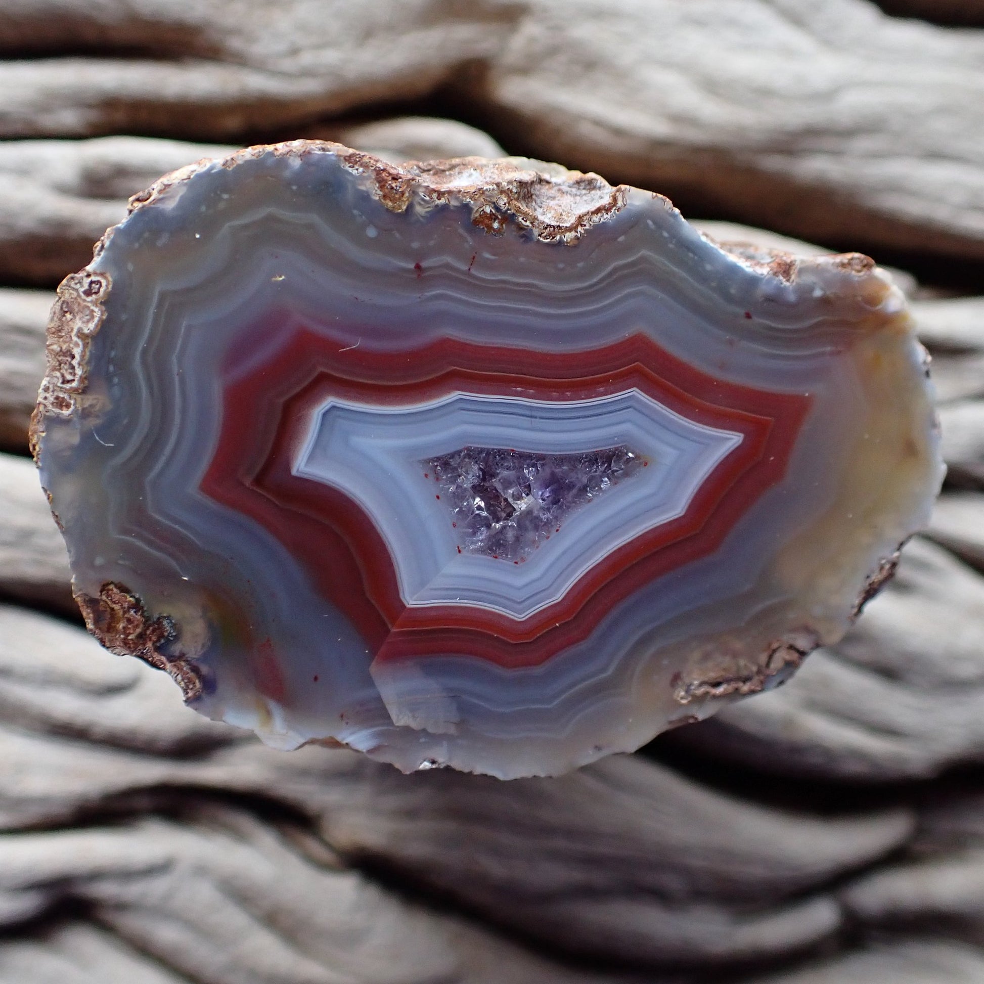Polished Malawi agate from the Ngabu region with lovely greys and reds into blue/white around an amethyst centre