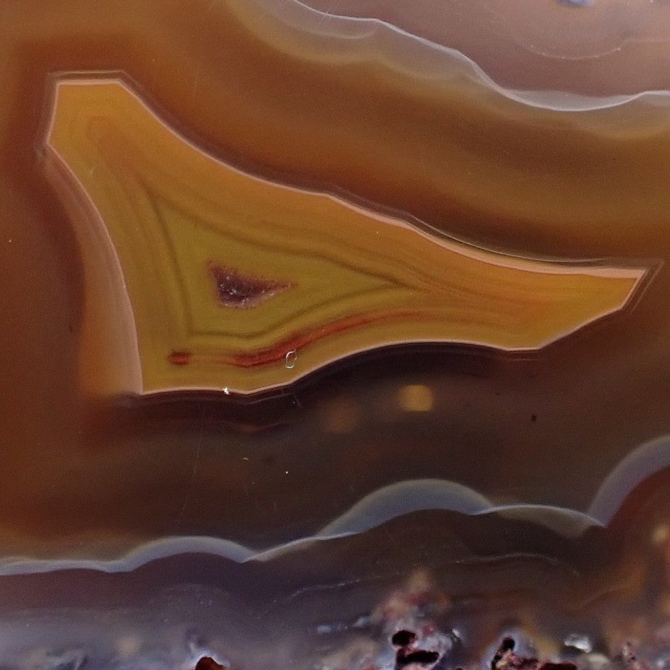 Close-up Malawi agate 45 mm – pointed inner banding structure, ghost banding in mid-brown zone, scalloped chalcedony outer band, warm-cool contrast, Ngabu origin | SKU 000387