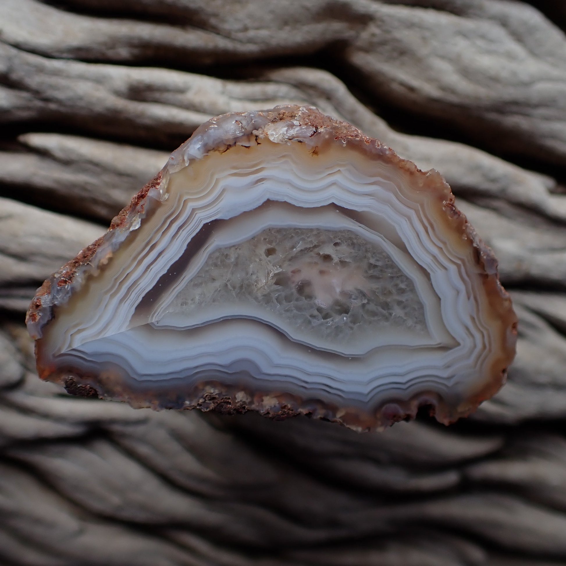 Polished Malawi agate from the Ngabu region with muted pastel colours around a crystalline centre with a floater