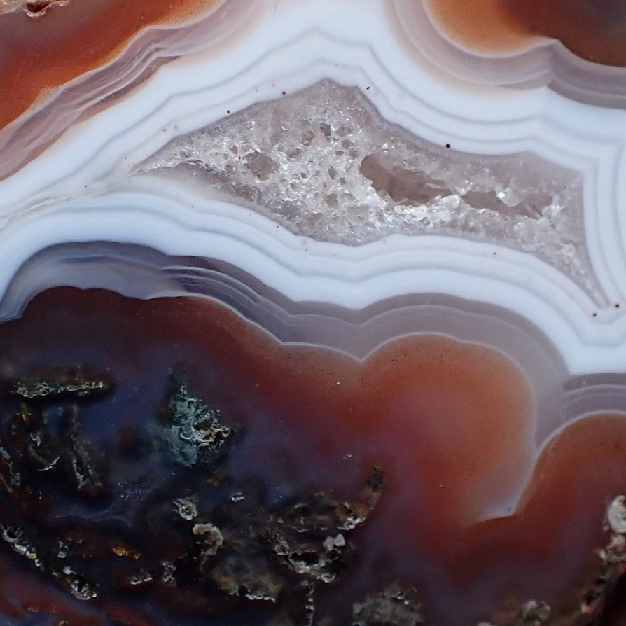 Crystalline centre of Malawi agate with white banding surrounded in orange with moss agate