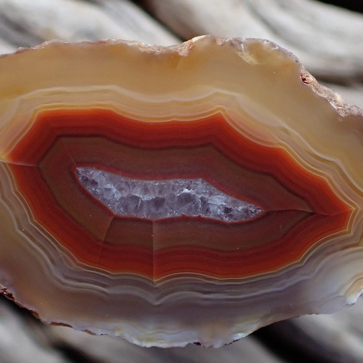 Close up of crystalline centre of Malawi agate with candy banding in reds and oranges