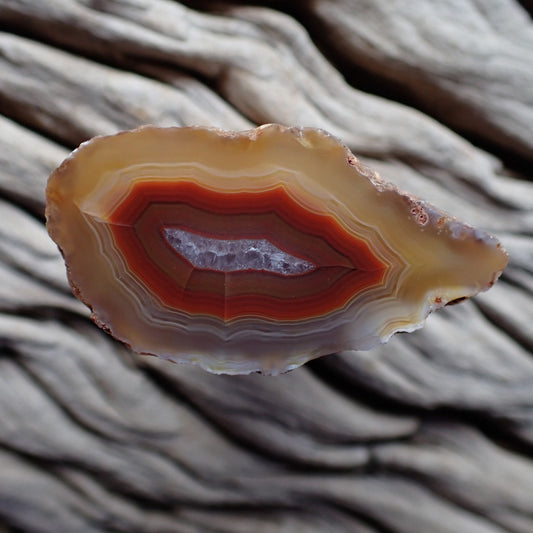 Polished Malawi agate from the Ngabu region with typical candy banding in reds and oranges with crystalline centre