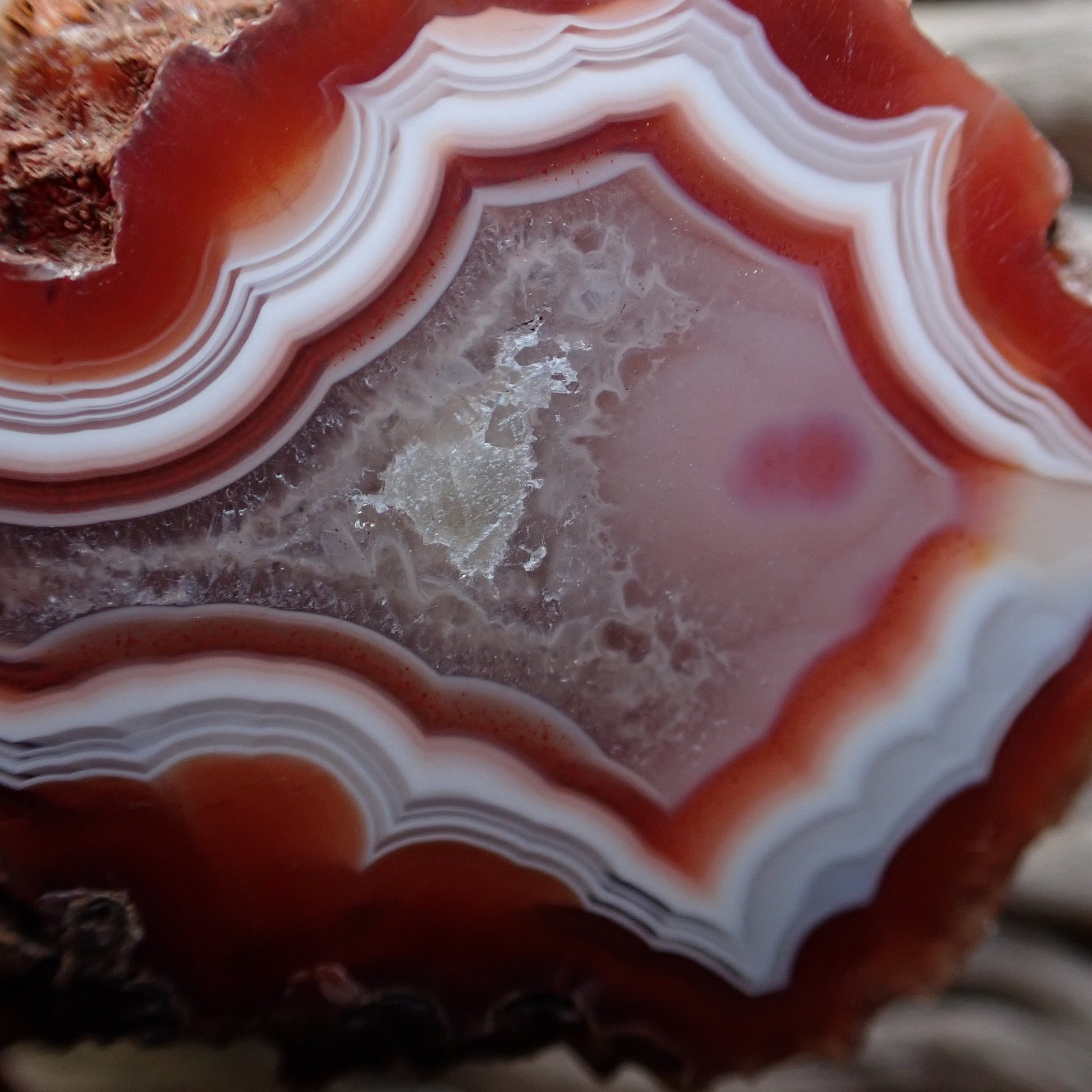 Close up of red and white Malawi agate with eye in crystalline centre