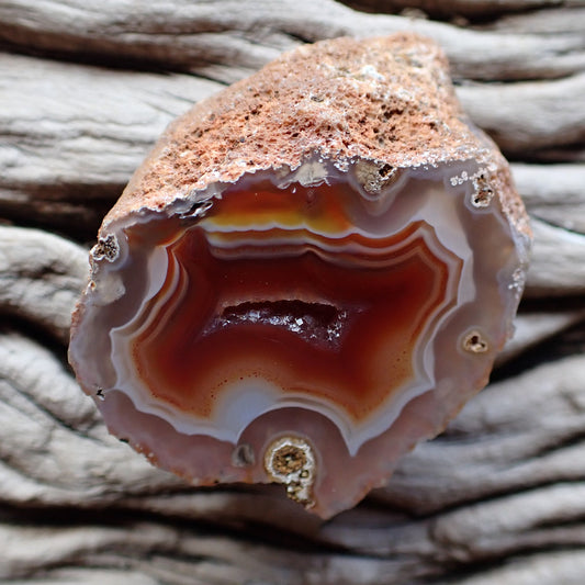 Malawi agate with ghost banding and mainly red orange and white colouring and a drusy centre