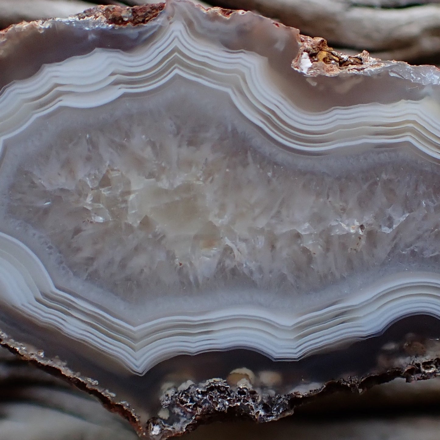 close up of the crystalline centre of a polished Malawi agate surrounded by white ands with strong parallax