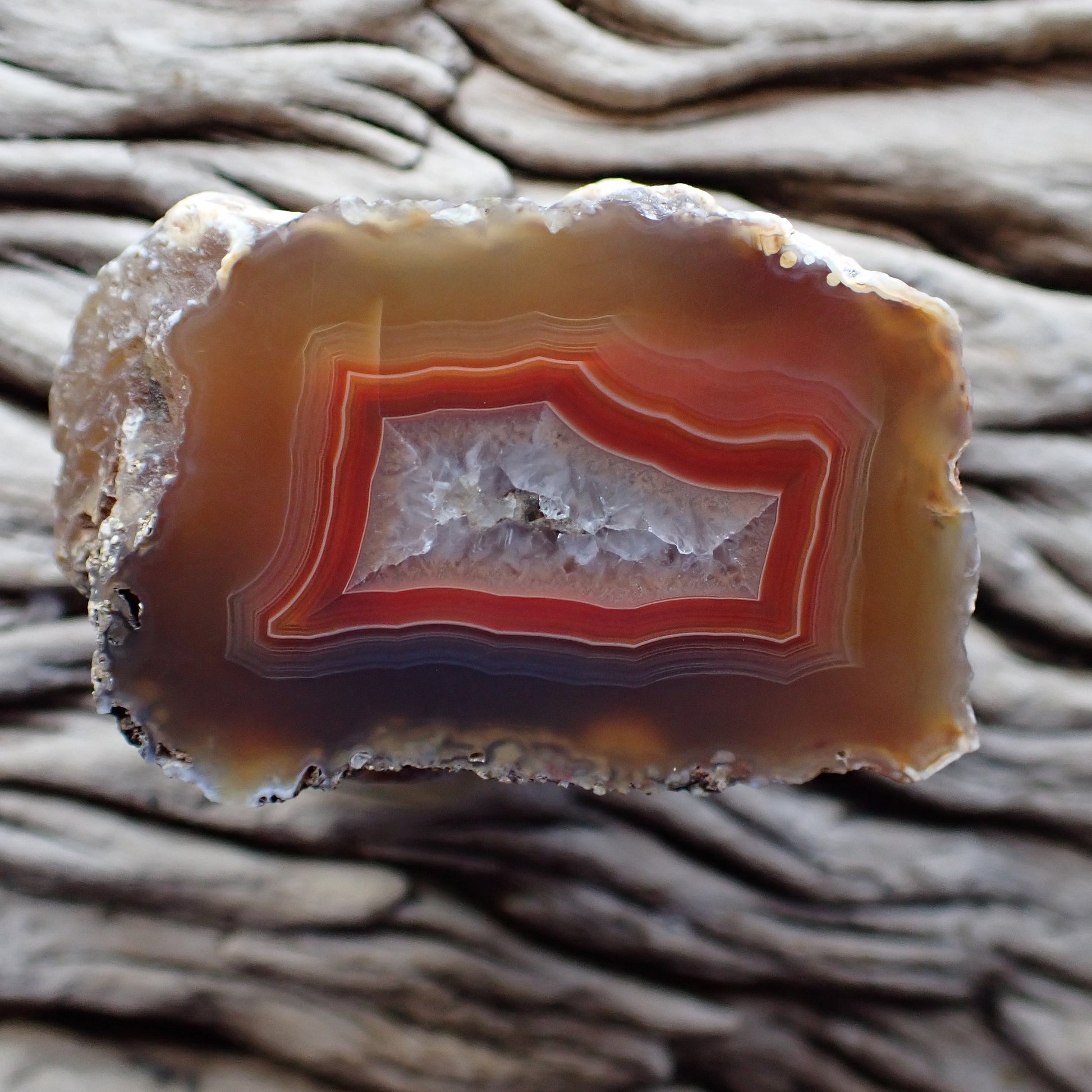 Malawi agate with a distinct rectangle shape with a bold red band around a shiny crystalline centre