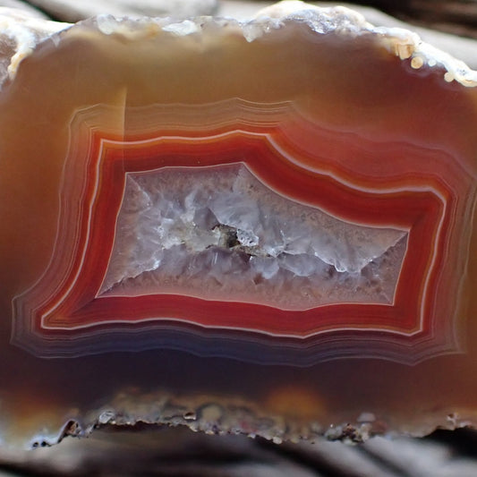 Close-up of a layered Malawi agate stone with red and white colors.