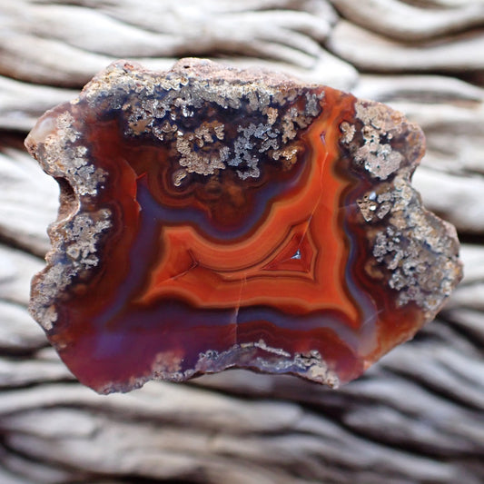 Vibrant Malawi polished agate featuring chromatism and flow channels. Bright colours of orange and purple