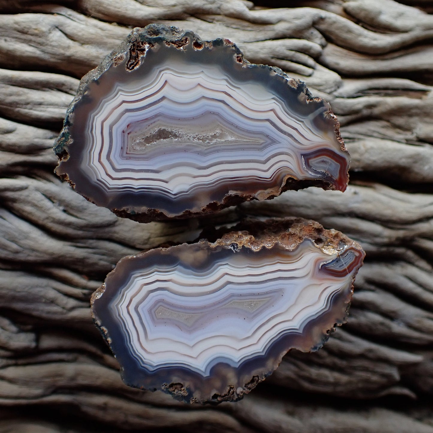 Stunning matching pair of Malawi ngabu agates with fortification banding in swirls of cream white and grey-blue going into a crystalline centre, both have matching flow channels
