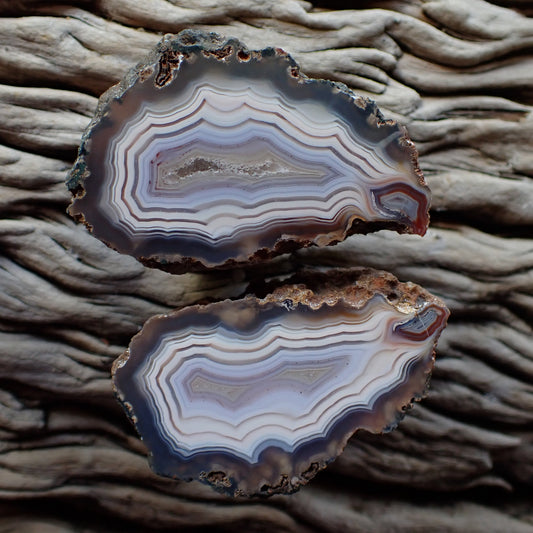 Stunning matching pair of Malawi ngabu agates with fortification banding in swirls of cream white and grey-blue going into a crystalline centre, both have matching flow channels