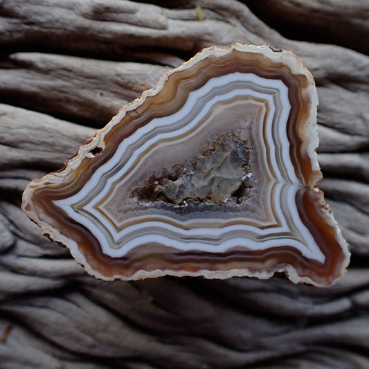 Malawi agate in lovely earthy tones featuring ghost banding, flow channel and a calcite centre