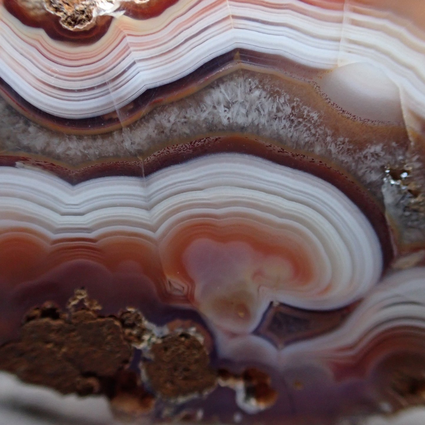 Close-up of a layered Malawi agate stone with concentric circles of color.