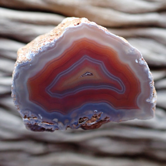 Multicolored Malawi Ngabu agate stone with concentric layers of orange and red and a subtle purple