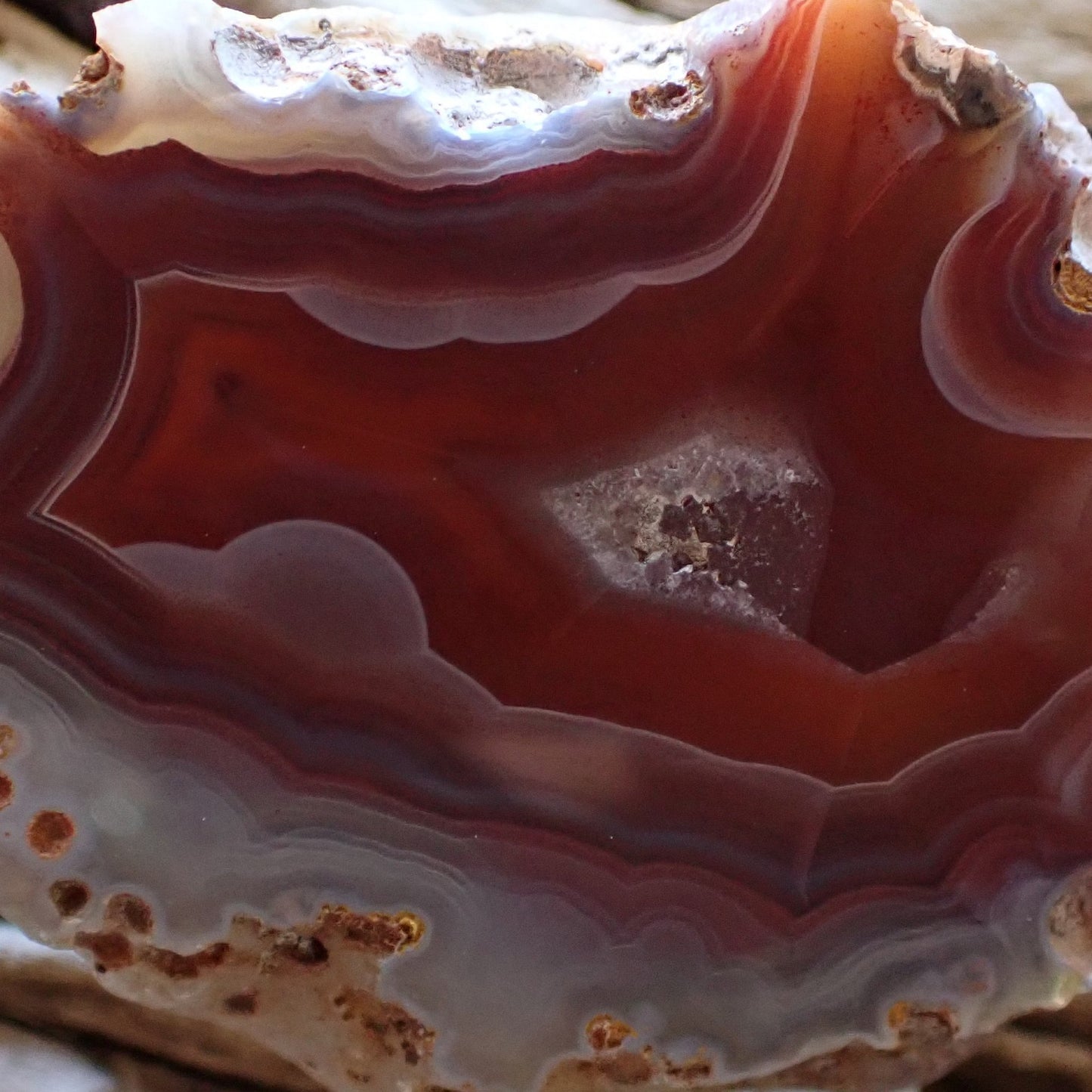 Cloe-up of a red Malawi Ngabu agate with lovely white ghost banding flowing into a flow channel