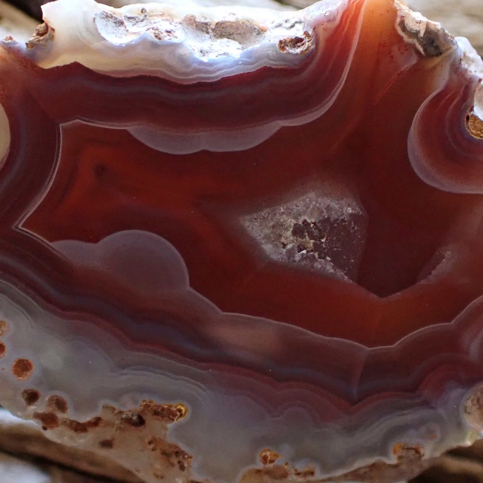 Cloe-up of a red Malawi Ngabu agate with lovely white ghost banding flowing into a flow channel