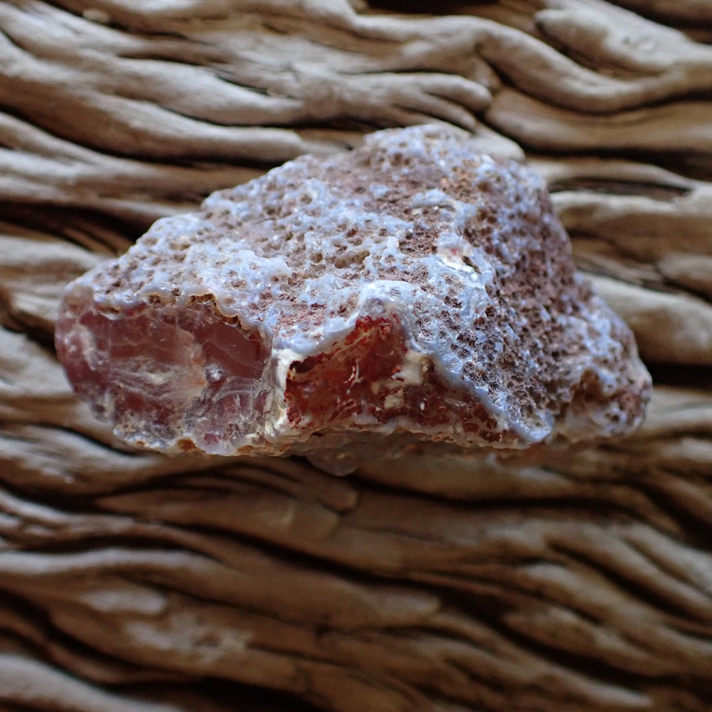 Rugged, unpolished husk of a Malawi agate, contrasting the rough, matte exterior with the hidden, colorful banding of the interior
