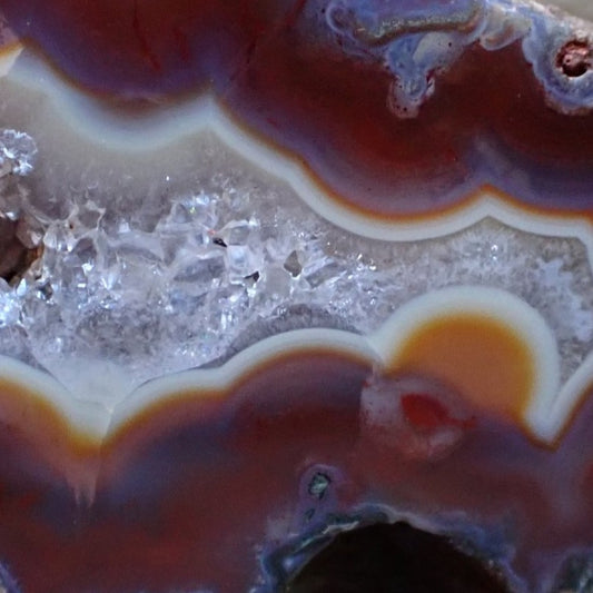 Close-up of Malawi agate 51 mm – macro-crystalline quartz vug with amber accent, scalloped band edges, blue-grey band and ghost banding detail | SKU 000480