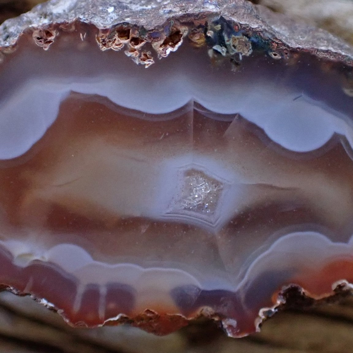 Natural hand-polished Malawi agate 50 mm – close-up detail, scalloped banding and diamond-shaped crystalline centre, Ngabu Malawi | SKU 000485