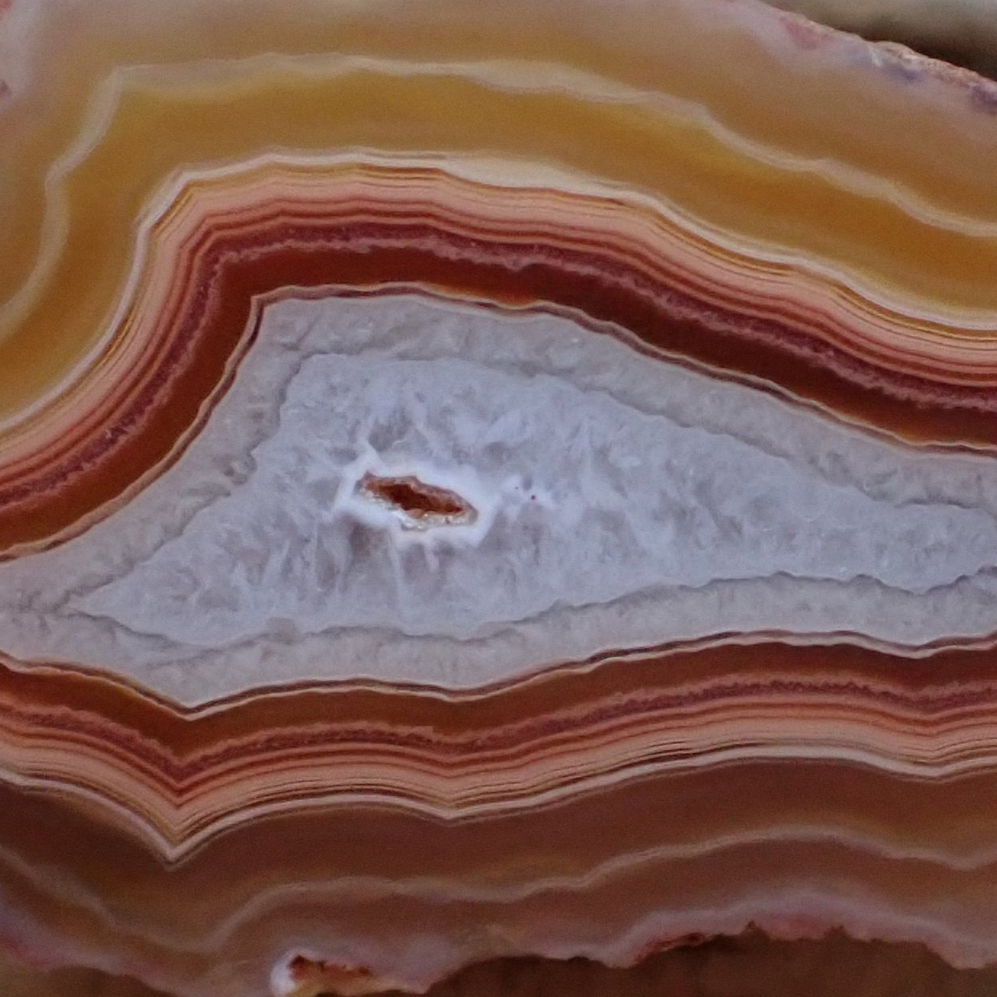 Arrowhead Malawi agate 56 mm – face detail, tight scalloped banding, warm-cool contrast, open vug at chalcedony centre | SKU 000490