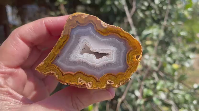 Lilangabi agate 70 mm – rotating view, floater with drusy vug, fortification banding, amber and white chalcedony